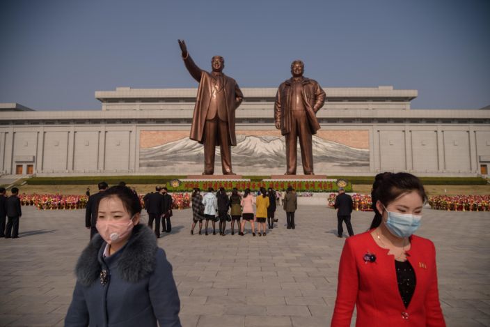 يغادر الناس بعد وضع الزهور أمام تماثيل كيم إيل سونغ وكيم جونغ إيل في بيونغ يانغ في 15 أبريل. (Kim Won / AFP via Getty Images)
