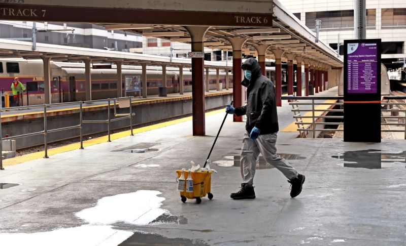 بوسطن ، ماساتشوستس - 13 أبريل: يمشي أمين الحراسة عبر منصات القطارات الفارغة في المحطة الجنوبية في بوسطن خلال جائحة COVID-19 في 14 أبريل 2020. (تصوير ديفيد ل. رايان / بوسطن غلوب عبر غيتي إيماجز)