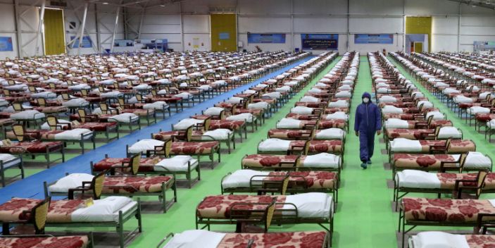 أحد أفراد الجيش الإيراني يمشي في صفوف صفوف الأسرة في مستشفى مؤقت بسعة 2000 سرير لمرضى الفيروس التاجي COVID-19 المقامة في شمال طهران ، إيران ، يوم الخميس ، 26 مارس ، 2020.