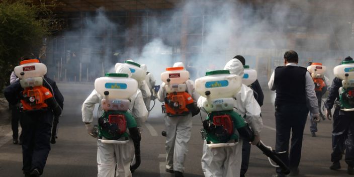 يقوم رجال الإطفاء بتطهير ساحة ضد فيروس التاجي الجديد ، في غرب طهران ، إيران ، الجمعة 13 مارس 2020.