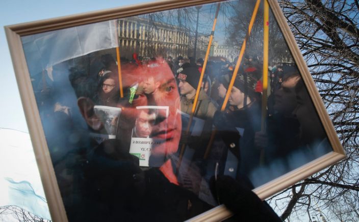 ينعكس المتظاهرون في إطار صورة خلال مسيرة في ذكرى زعيم المعارضة بوريس نيمتسوف في سان بطرسبرج ، في 29 فبراير.