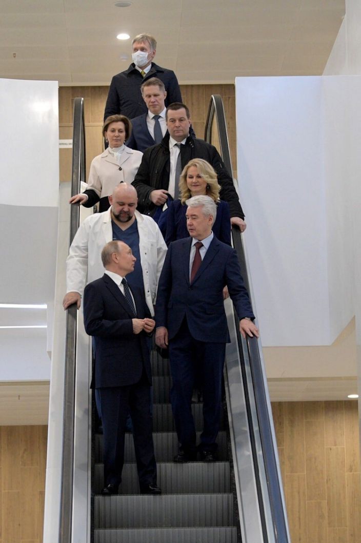 المتحدث باسم الكرملين ديمتري بيسكوف (في الأعلى ، يرتدي قناع الوجه) والرئيس الروسي فلاديمير بوتين (في الأسفل) يزوران مستشفى كوموناركا لمرضى الفيروس التاجي في موسكو في 24 مارس 2020.