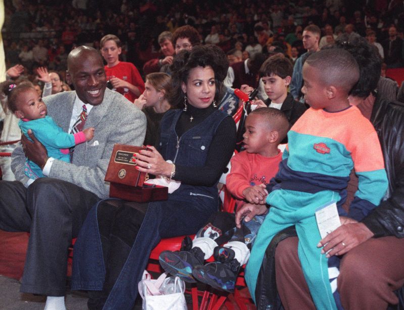 نجم شيكاغو بولز المتقاعد مايكل جوردان ، إلى اليسار ، يحمل ابنته ياسمين بينما زوجته جوانجيتا وأولاده ماركوس وجيفري ، على اليمين ، انظروا إلى العرض التالي لخواتم بطولة الدوري الاميركي للمحترفين لعام 1993 قبل افتتاح منزل بولز ضد ميامي هيت في 6 نوفمبر. 1993 ، في ملعب شيكاغو.